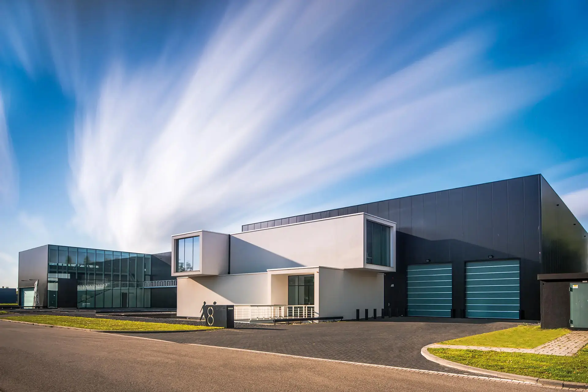 a building with a parking lot and a blue sky
