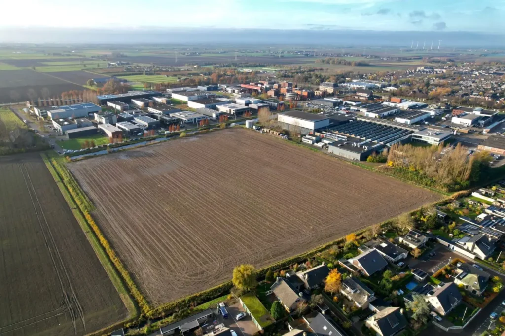 a large field with buildings in the background